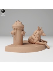 Coyote resting next to a fire hydrant